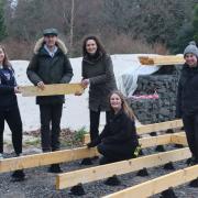 Patrick (Options in Life group member seen demonstrating to Wendy Chamberlain MP North East Fife how the group got hands on and involved with a whole variety of tasks in the garden from planting, pruning and maintenance during their work placement.
